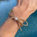 gold beaded bow bracelet with pearl in the middle