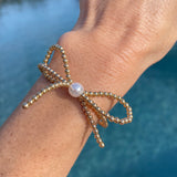 gold beaded bow bracelet with pearl in the middle